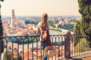 Rear view of woman holding Italian flag in Verna city- Travel destination, tour tourism in Italy,...