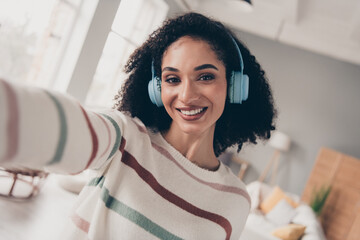Photo of sweet positive lady dressed striped pullover tacking selfie listening songs headphones...