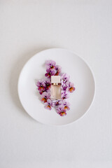 Purple Pansy Flowers on Modern Plate with Natural Looking Perfume Bottle