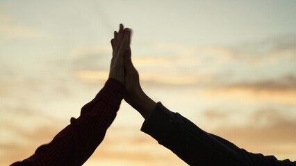 High five hands at sunset silhouette. Best friends buddies clapping each other palms in field park at dawn. Teamwork successfully completed business celebration rejoicing friendly feelings expression