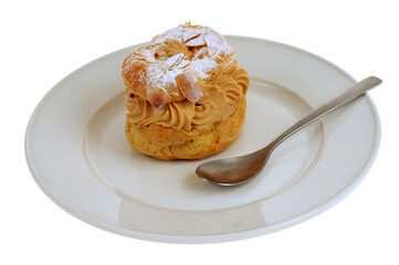 Paris-Brest dans une assiette avec une cuillère en gros plan sur fond blanc