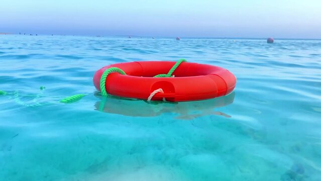 Rescue saving life buoy floating in open ocean sea over blue calm water surface.prevent person from dangerous drowning emergency concept.Swimming,summertime holiday