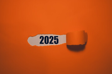 2025 on paper with orange colour cover peeled in concept of new year business plans new year...