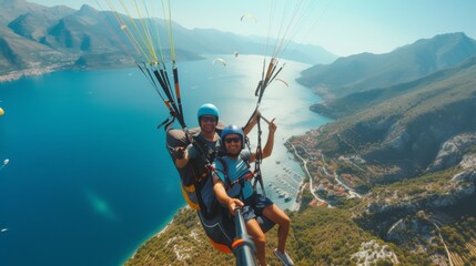 Obraz premium Two adventurers fly side by side on a paraglider on a sunny day