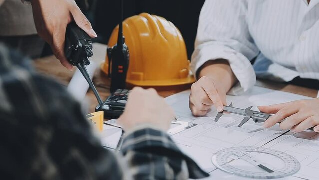 Civil engineer teams meeting working together wear worker helmets hardhat on construction site in modern city. Foreman industry project manager engineer teamwork. Asian industry professional team