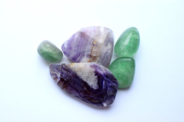 Sections of beautiful striped purple fluorite and green fluorite stones close up on a white...