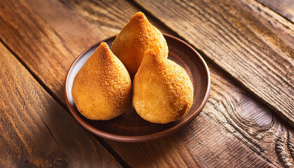 Close-up of Brazilian coxinha over wooden table. Chicken dish. Tasty meal. Delicious food for dinner