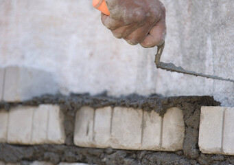 Worker plastering brick wall with trowel, stock photo