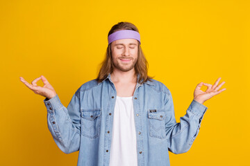 Photo portrait of attractive young hippie man meditate closed eyes wear trendy denim outfit isolated on yellow color background