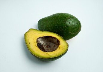 Sliced in half green unripe not ready to eat avocado fruit or vegetable object photography isolated...