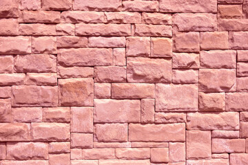 Abstract geometric background of wall lined with decorative stone tiles. Toned in pink clolor....