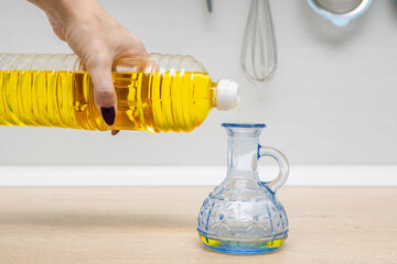 housewife pours sunflower oil into a glass bottle