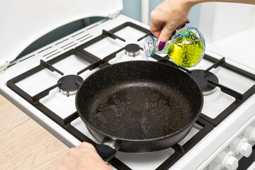 housewife pours frying oil into a frying pan.