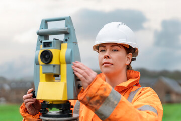 Professional Female site engineer surveyor working with theodolite total station EDM equipment at  building construction site  