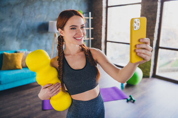 Photo of young pretty fitness girl hold roller make selfie smart phone sportswear training...