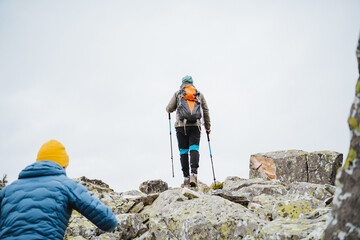 Two mountaineers climbing rocky slope, enjoying scenic landscape