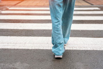 legs of woman in jeans crossing road on pedestrian zebra crossing Lifestyle people