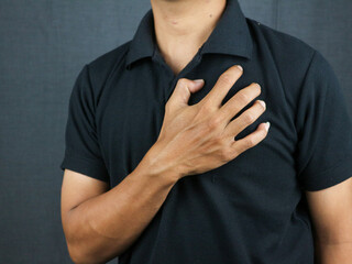Man clutching his chest from acute pain. Heart attack symptom pressing on chest having painful cramp