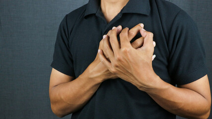 Man clutching his chest from acute pain. Heart attack symptom pressing on chest having painful cramp