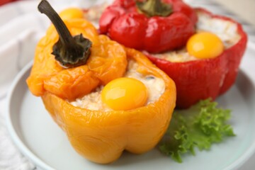 Delicious stuffed bell peppers with fried eggs on table, closeup