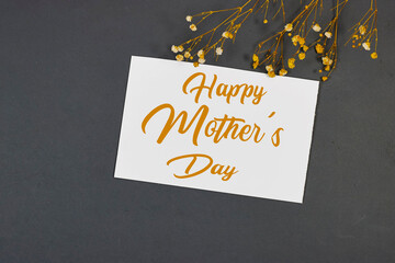 Mother's Day decorations concept. Top view photo of white invitation card with gypsophila flowers on gray background