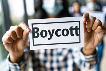 Woman hand holding card with the inscription "Boycott"