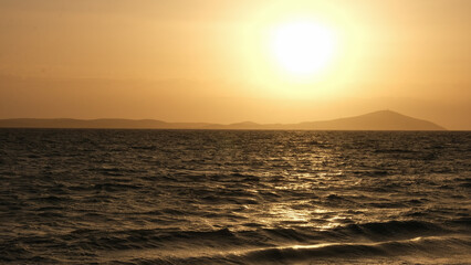 Obraz premium Bozcaada sunset in Aegean Island from Geyikli neighborhood at Çanakkale city. Golden hours with sea and island at Bozcaada.