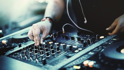 Dynamic DJ Set: Closeup of Unrecognizable DJ Mixing Tracks with CD Players and 4-Channel Mixer at...