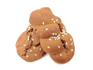 Closeup view of two delicious Greek soft grape molasses cookies (moustokouloura), isolated on white background.