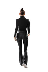 A woman from behind holding a laptop, wearing black clothes and white sneakers, on a white...