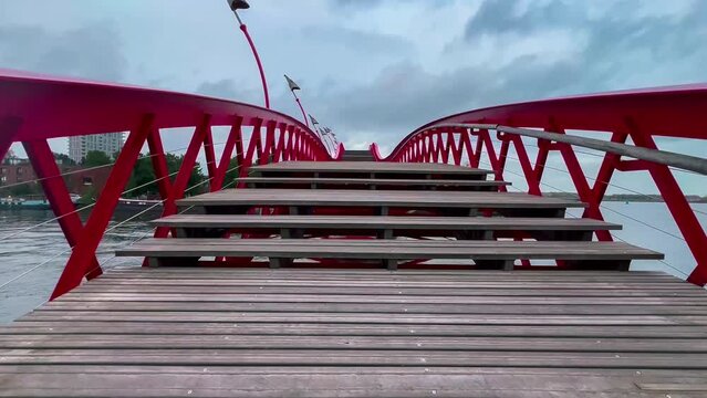 Modern footbridge Python Bridge at Eastern Docklands neighborhood of Amsterdam Netherlands. High quality 4k footage