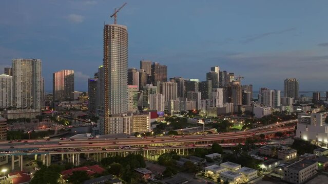 Aerial view of cars driving on Downtown I95 Riverside multilane highway at blue hour with Miami skyline view. Drone flight over rush hour traffic on the highroad in Miami