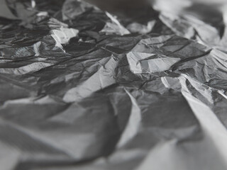 Abstract background of crumpled plastic film. White wrapping paper of Tyvek. Grey.