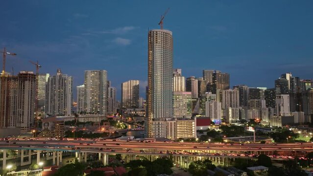Establishing aerial view of vehicles driving on Downtown I95 Riverside multilane highway at night, transport infrastructure in Miami. Drone flight over multi-level intersection Miami Florida