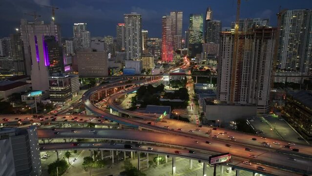 Aerial cinematic shot of cars driving on Downtown I95 Riverside multilane highway at night, transport infrastructure in Miami. Drone flight over rush hour traffic on the highway in Miami 