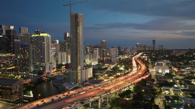 Establishing aerial shot of vehicles driving on Downtown I95 Riverside multilane highway at night in Miami. Drone flight over multi-level intersection Miami Florida. Best Miami aerial shot