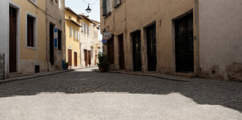 Fototapeta premium An ancient European narrow street. Cobblestones, low bright houses, without people.