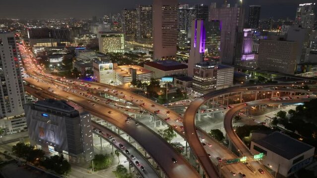 Aerial view of vehicles driving on Downtown I95 Riverside multilane highway at night, transport infrastructure in Miami. Drone flight over multi-level intersection Miami Florida