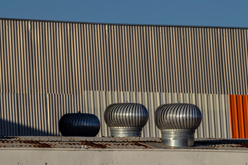 Ventilation heater on roof in brazilia factory. Rotary chimney aspirator on the industrial roof in...
