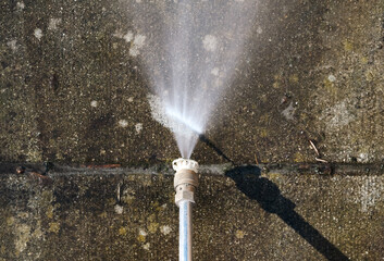 Concrete tile cleaning with pressure washer. Top view of high pressure water jet. Patio, balcony or...