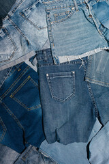 Background of many denim items with pockets. Pants, shorts, jackets.