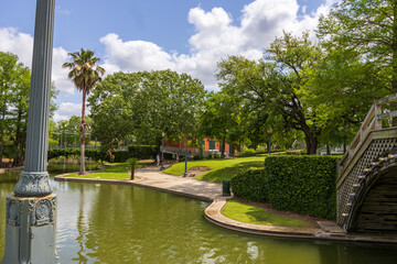 a gorgeous spring landscape at Louis Armstrong Park with lush green trees, plants and grass, a...