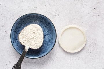 All purpose flour in a silver shaped measuring cup, one cup of flour in a metal measuring cup