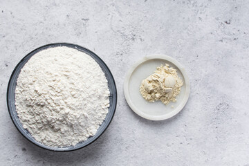 All purpose flour and vital wheat gluten in a ceramic bowl, process of making bread flour