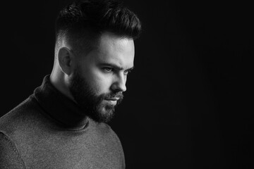Portrait of handsome bearded man on dark background, space for text. Black and white effect