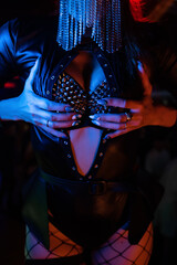 Beautiful dancer posing in a nightclub. Studded lingerie close-up. atmospheric light. Party...