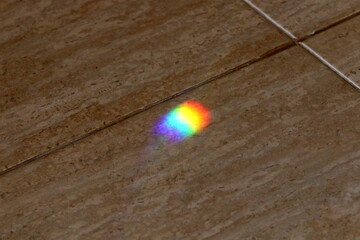 A multi-colored sunbeam is reflected on the tiles.