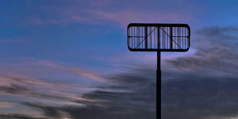 Looking up at a an empty commercial sign frame with a beautiful blurred partially cloudy sunset or...