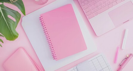 top view of pink notebook, laptop and stationery on white background