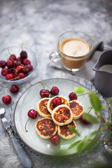 Cottage cheese pancakes with fresh cherry and coffee for breakfast